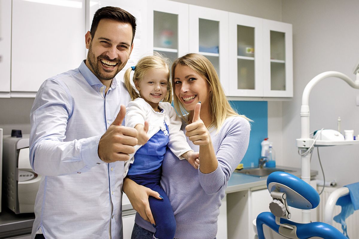 Parents with their child at a pediatric dental office discussing dental care and treatment